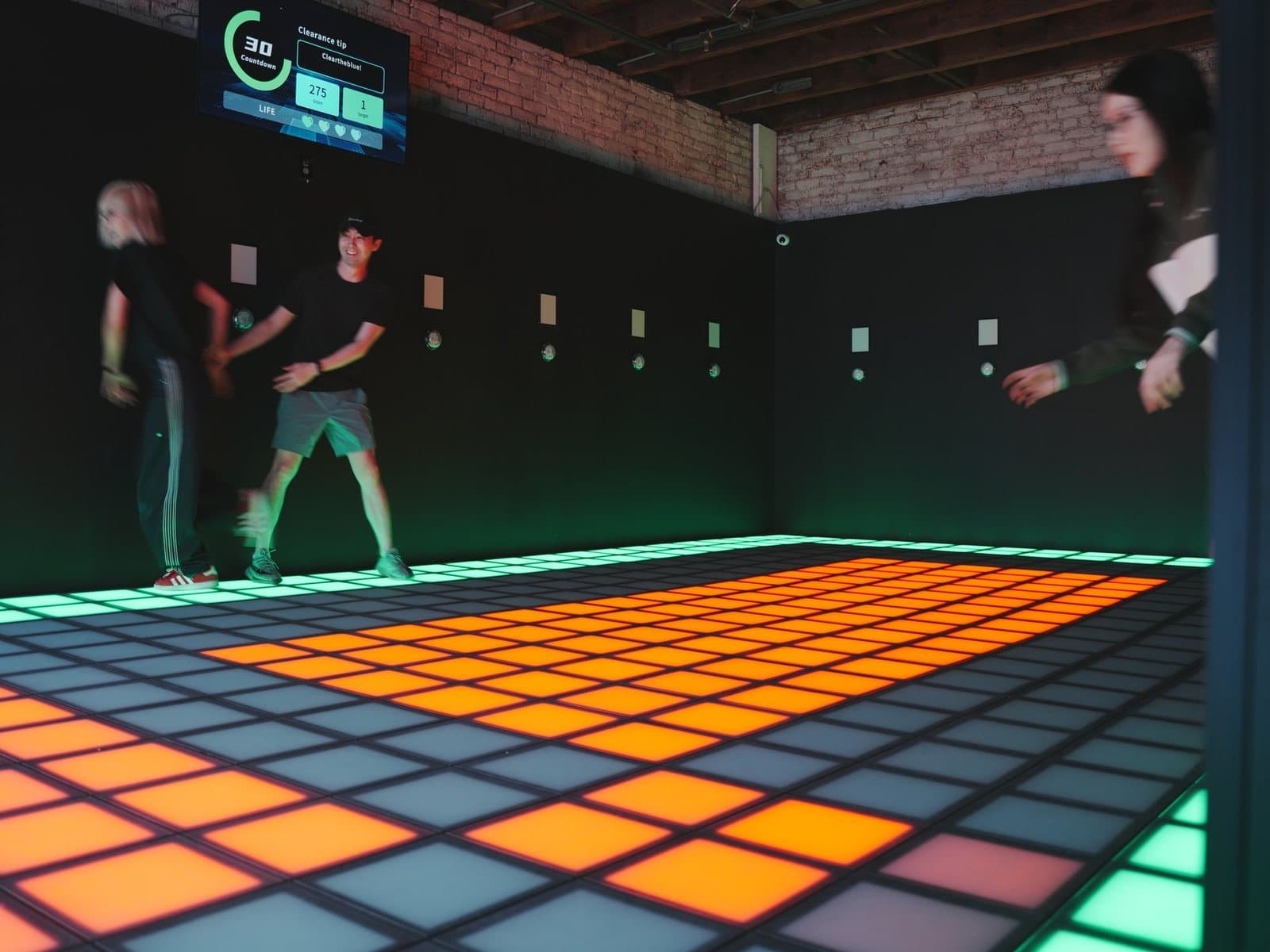 A group playing on the glowing orange Pixel XL floor at Simple Pixel