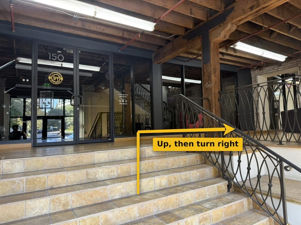 Short flight of tan tiled steps leading up to a landing, with glass doors marked 150 on the left and an iron railing on the right.