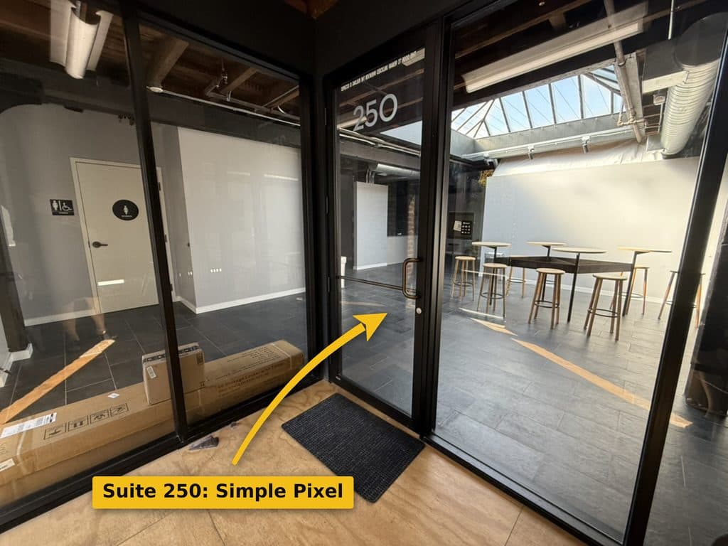 Glass double doors marked 250 opening into a bright room with a skylight and high-top tables.